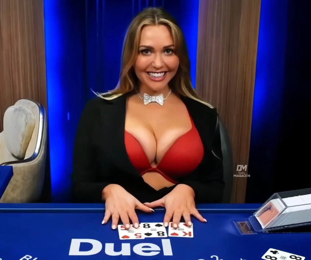 Mia Malkova seated at the blue Duel blackjack table dealing cards